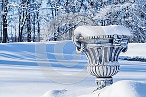 Big flower pot covered in fresh snow