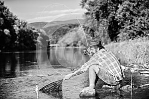 big game fishing. relax on nature. hipster fishing with spoon-bait. fly fish hobby of man. Hipster in checkered shirt