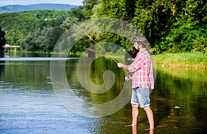 Big game fishing. relax on nature. mature bearded man with fish on rod. successful fisherman in lake water. hipster