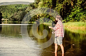 big game fishing. relax on nature. mature bearded man with fish on rod. successful fisherman in lake water. hipster