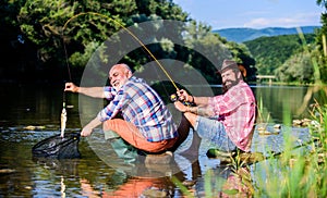 Big game fishing. relax on nature. retired father and mature bearded son. happy fishermen friendship. Two male friends