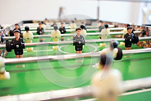 Big game table football in a bright room. Figures of soccer players close-up