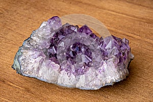 Big geode found in europe with white and purple crystals in the inside on wooden underground