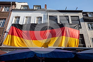 Big German Flag cover building over restaurant, pub or cafe in old town DÃ¼sseldorf Germany.