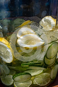 Big glass glass jar with tap filled with fresh healthy lemon lemonade drink served in bar for party close up