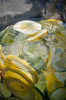 Big glass glass jar with tap filled with fresh healthy lemon lemonade drink served in bar for party close up