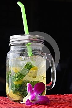 Big glass of mojito with orchid flower on black