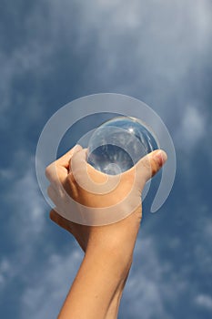 big glass sphere and a hand of a child