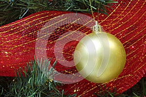 Big gold christmas bauble in a tree red ribbon