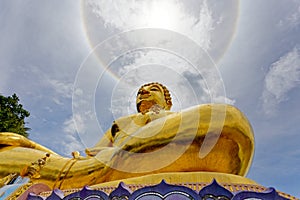 Big gold statue buddha under corona ring sun light