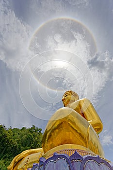 Big gold statue buddha under corona ring sun light