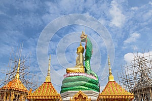 Big golden buddha statue during construction sitting in public thai temple