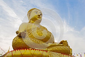 Big Golden Buddha statue over scenic white and blue sky at Wat S