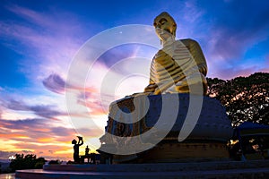 Big Golden Buddha statue Sitting on Lotus meaning at Sunset