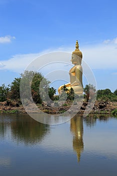 Big golden buddha statue sitting reflection on the water