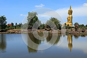 Big golden buddha statue sitting reflection on the water