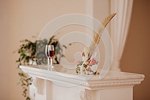 Big golden feather and glasses with rose champagne. Folder with documents on signing marriage certificate, writing materials