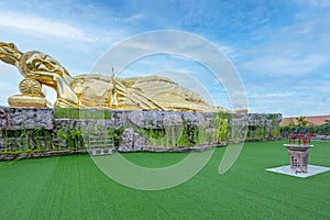 Big golden Guanyin Golden statue of a lying with sky background