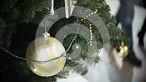 Big golden matte ball and lights. New Year`s and abstract blurred shopping mall background with Christmas tree