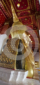 Big golden reclining buddha statue in ubosot or chapel at Wat Ph