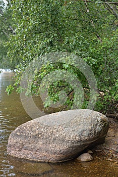 Big granite stone on coast of lake