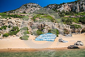 Big greek flag painted on large rock at Tsambika beach at Rhodes island in Greece