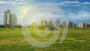 Big green field in front of residential buildings