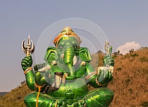 The big green Ganesh statue in the midst of nature In Ratchaburi