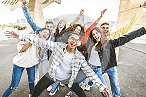 Big group of happy friends with arms up smiling at camera together - Multiracial young people having fun outdoors