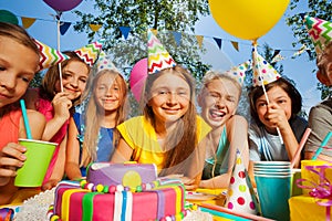 Big group of smiling kids around birthday cake