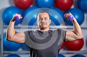 Big guy holding ridiculously small dumbbells