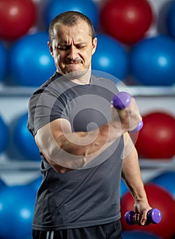 Big guy holding ridiculously small dumbbells