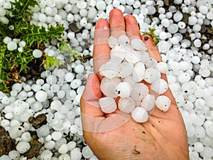 Big hailstones in the hand with hailstones in background