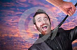 Big hand grabbing the necktie of young businessman