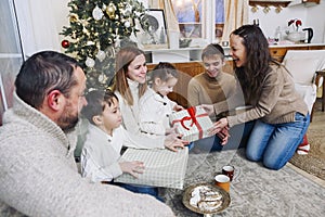 Big happy family with children gathering at home around New Years festive tree