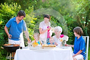 Big happy family grilling meat with grandmother