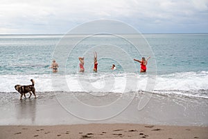 Big happy family or group of five friends is having fun against sunset beach. Beach holidays concept.