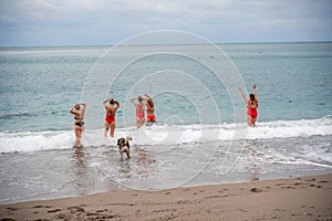 Big happy family or group of five friends is having fun against sunset beach. Beach holidays concept.