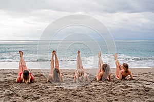 Big happy family or group of five friends is having fun against sunset beach. Beach holidays concept.