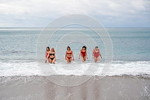 Big happy family or group of five friends is having fun against sunset beach. Beach holidays concept.