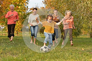 Big happy family playing football in autumn park