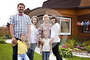 Big happy family portrait on the background of a country house