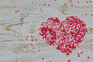 A big heart made from colorful little hearts. On wooden background, photo bokeh. Valentine`s day holiday. Valentine card.