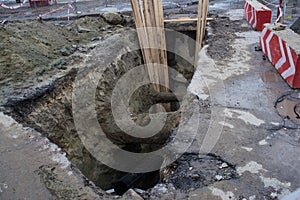 Big hole in road made for road repairing works with caution sign