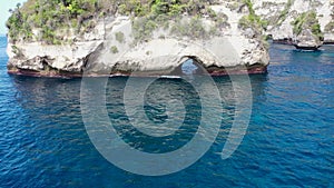 Big hole in Rocks. Tunnel in the cliff in the ocean at Diamond beach in Nusa Penida island, Bali in Indonesia. Aerial