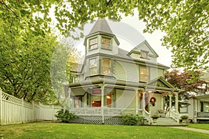 Big home with nice front yard, porch, white railings and walkway