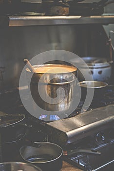 A big hot pot of thai curry while cooking on the gas stove in thai restuarant in USA..