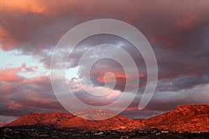 Big huge sunset clouds over the red mountains in Tucson Arizona