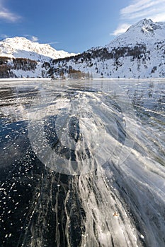 Big ice cracks refilled with underwater and freeze again on the frozen lake