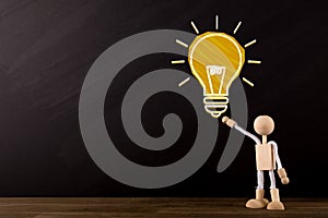 Big idea concept, Big Yellow light bulb sketch and Wooden Stick Figure pointing at light bulb